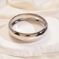 Dettaglio ravvicinato di un bracciale in metallo argento liscio su un piedistallo di pietra - Argento - Piccolo