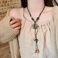 Detail of bohemian necklace with colorful ceramic beads and long leather fringe tassels - Multi-color