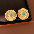 Primo piano di orecchini vintage a fiore con pietra blu e zirconi in una scatola regalo - Oro