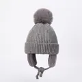 Detailed view of grey knit hat with faux fur pompom and braided chin straps - S / Gray