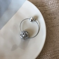 Détail d'un bracelet argenté avec rose et perle sphérique sur un plat en céramique - Élastique Rose Argentée