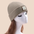 Khaki ribbed knit beanie with outdoor adventure woven patch on a white model head - Khaki