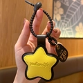Yellow star leather keychain with black rubber loop and embossed branding details - Leather-Yellow Star