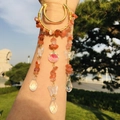 Close-up of golden moon suncatcher with raw orange crystal beads and butterfly charms - Red Agate