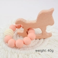 Baby wooden rocking horse teether with pink silicone beads on a white woven coaster - Rocking Horse/Pink Beads