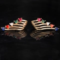 Macro detail of gold-plated wing earrings featuring multi-color heart-shaped gemstones - Colorful