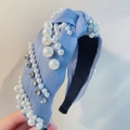 Detail eines hellblauen Stirnbands mit Knoten, weißen Perlen und glitzernden Steinen - Schräges Blau