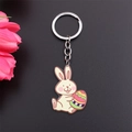 Close-up of a cartoon bunny holding an Easter egg metal enamel keychain detail - Easter Egg Yellow Rabbit