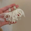 Orecchini ad ago in argento con nappe in pizzo bianco e dettagli in perle lucide - Perno in argento 925 / Orecchini con fiocco bianco