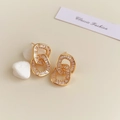 Detailed macro view of 18K gold intertwined hoop earrings with zircon stones on pebble - 18K Gold Plated Golden Double Circle Zirconia Studs
