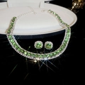 Macro view of silver jewelry set with green stones and starburst light effect in gift box - Green Round Main Stone Halo / Silver-Green