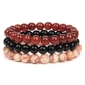 Detailaufnahme von drei gestapelten 8-mm-Natursteinperlenarmbändern in Rot, Schwarz und Weiß - Nr. 7 Roter Achat/Schwarzer Achat/Rot Gemustert