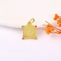 Macro detail of ancient style gold shield pendant with red and green gemstone inlays - 13# Sand Gold Bagua Plaque with Zircon