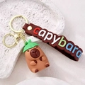 Porte-clés Capybara mignon avec chapeau feuille verte et lanière en cuir marron - Chapeau de Paille