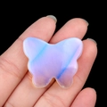 Carved butterfly crystal opal stone with blue sheen held between fingers - Synthetic Opal / 30*35mm No Hole