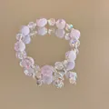 Detail of beaded bracelet with pink crackle beads, crystal charms, and butterfly pendant - Silver-White-Butterfly