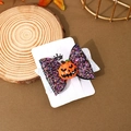 Detail of Halloween hair clip with pumpkin charm and glitter bow on a wooden base - Resin Pumpkin