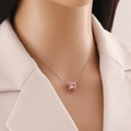 Gros plan d'un pendentif en zircone rose carrée sur une chaîne dorée en acier inoxydable - Rose
