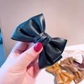 Dettaglio di fermagli per capelli in pelle PU con fiocco vintage in vari colori - Nero