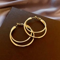 Dettaglio di orecchini a doppio cerchio dorati con strati metallici lisci e lavorati - Cerchi A Doppio Strato / Oro