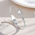 Detail of silver titanium steel bracelet featuring double hearts with white mother of pearl - Double Heart Mother of Pearl Bangle (Silver)