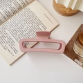 Détail d'une pince à cheveux carrée rose mat avec une texture givrée sur un livre - Carré Grand Mat Kaki