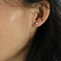 Minimalist tiny white round stud earring shown on ear for a delicate daily look - 3mm / White