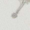 Silver flower pendant necklace with clear zircon stones on a beige textured background - Flower Style (XL2433) / Silver