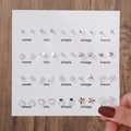 Gros plan de 30 paires de boucles d'oreilles argentées avec perles et motifs de cœur - E1680-1