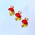Close-up of red enamel mushroom charms with gold borders for DIY jewelry making - Red Mushroom