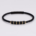 Dettaglio di un bracciale da uomo in pelle nera intrecciata con ciondoli in metallo - Bicolore Nero