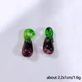 Détail macro de deux pendentifs aubergine en verre violet, dimensions 2,2x1cm et 1,6g - Aubergine violette
