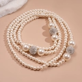 Close-up of multilayer faux pearl necklace with sparkling pavé crystal spheres - White