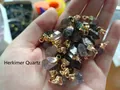 Natural Herkimer Diamond quartz crystal pendant with golden metal cap held by hand - Herkimer Diamond