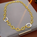 Dettaglio collana dorata con maglie ovali in smalto bianco su una scatola da gioielli - Collana (WN1654) / Oro+Bianco