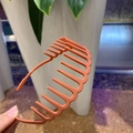 Detail of matte orange-pink hairband showing internal anti-slip teeth and frosted texture - Orange