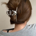 Detail view of a large silver heart-shaped metal claw clip styled on a woman's hair - Silver Heart Shape Style (FJ2415)