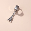 Silver stainless steel huggie hoop earring with Eiffel Tower charm on beige background - Eiffel Tower