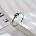Makroaufnahme eines ovalen grünen Edelsteinrings mit Diamanten auf weißem Podest - Einstellbar Offen / Silberfarben Grüne Zirkonia Ring