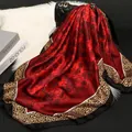 Elegant red silk square scarf with black floral print and leopard border on a handbag - Noble Red Leopard Rose