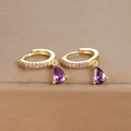 Elegant gold drop earrings with purple pear-cut crystals and pavé stones on a display box - Gold Purple Zirconia