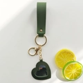 Detail view of dark green leather heart mirror keychain with gold hardware on white background - Army Green
