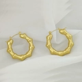 Close-up of golden U-shaped earrings with bamboo texture on white draped fabric - Bamboo Texture Hoop Style (XL1464-63)