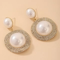 Dettaglio macro di orecchini geometrici in oro con perle bianche e strass scintillanti - Perno in Argento - Orecchini con Perle Bianche