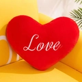 Rotes herzförmiges Plüschkissen mit Love-Stickerei auf einem gelben Sofa - 15cm / Rot