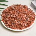 Irregular natural red crystal quartz stone chips displayed in a white round dish - Golden Sun (7-9mm) 100g