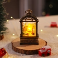 Close-up of a vintage bronze Christmas lantern night light with Santa Claus on a wooden base - Brushed Gold Santa Claus
