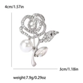 Broche de rosa plateada con diamantes de imitación y perla sobre fondo blanco - Plateado