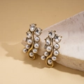 Detalle de pendientes vintage dorados con perlas sintéticas y cristales brillantes - Pendientes con poste de plata / Dorado