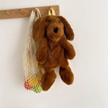 Cute brown plush puppy backpack with yellow straps hanging on a wooden hook - Brown